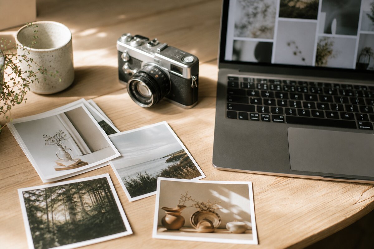 Bureau met foto-prints en een camera